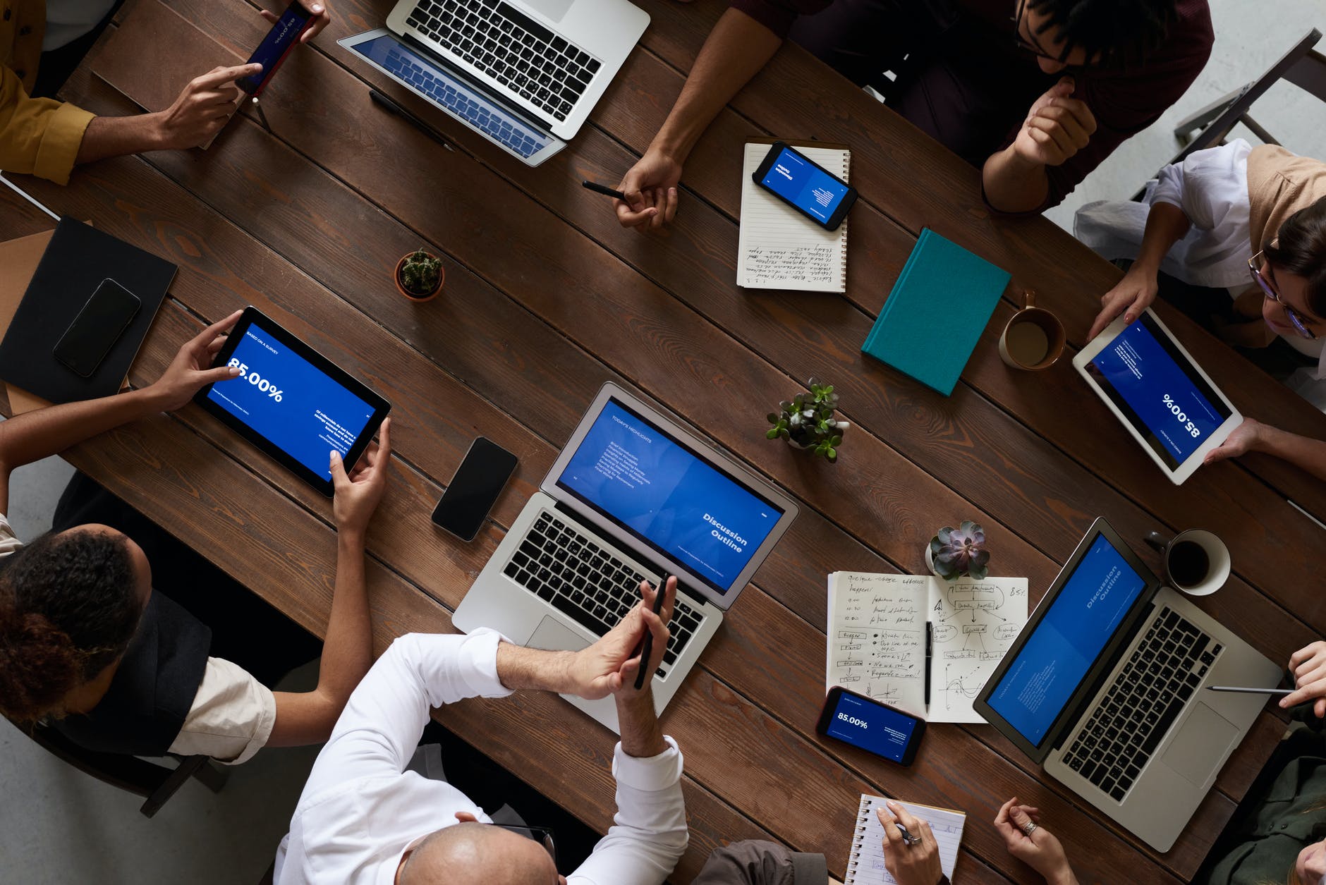 An aerial photo of people sat around a table on laptops