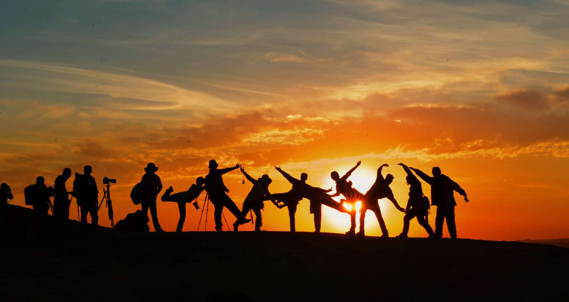 Group of people on a hill in the sunset