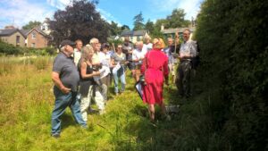 People surveying a hedge on a sunny day in Chagford