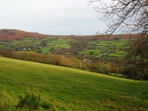 A landscape made up of moorland, fields, woodland and a village