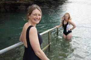 Two women entering the water to swim